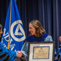 Provost Mili shakes hands with woman as President Mantella applauds